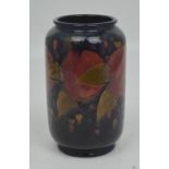 A Moorcroft cylindrical footed vase, tube-line decoration of pomegranates against a blue ground,