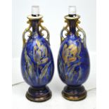 A pair of ceramic blue ground baluster twin-handled lamp stands with Oriental style silk shades,