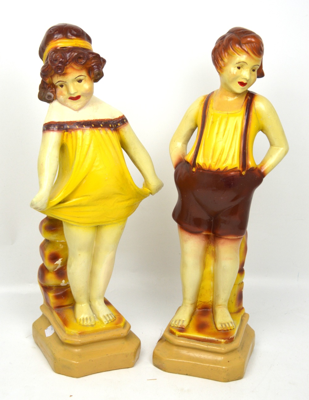 A pair of 1930s decorative figurines of a young boy and girl at the seaside, height 54cm (2).