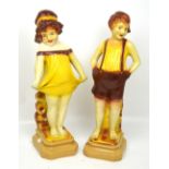 A pair of 1930s decorative figurines of a young boy and girl at the seaside, height 54cm (2).