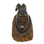 An African Dan tribe carved wooden wall mask, the face of oval form with open mouth and closed eyes,