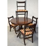 A circular mahogany reproduction dining table on quatrefoil support,