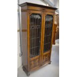 An early 20th century oak Arts and Crafts style astragal glazed two-door bookshelf,