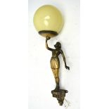 An Art Deco wall light in the form of a young woman holding a glass spherical globe shade,