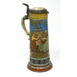 A large Mettlach tankard with hinged pewter and ceramic lid, height 40cm.