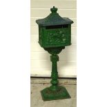A green painted free standing cast iron letter box, height approx 118cm.