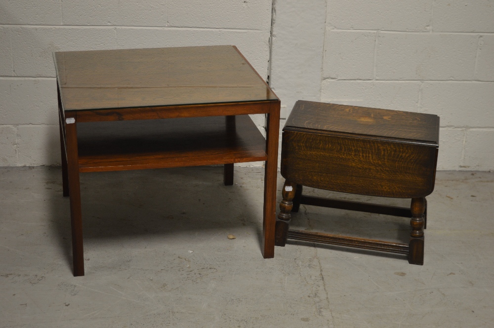 A South American hardwood glass topped two-tier coffee table on block supports,