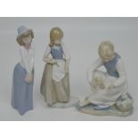 Three Nao figures; a boy, a girl and a larger example of a seated young lady rubbing her feet (3).