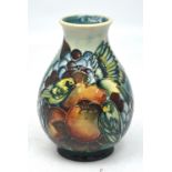 A Moorcroft vase, tube-line decorated with finches amongst fruit on a graduated green ground,