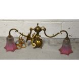 An Edwardian brass two-branch adjustable light fitting with graduating pink bell shaped shades,