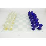 A 20th century Czech Republic crystal blue and clear glass chess set with glass board, cased.