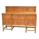 An early 20th century oak sideboard with moulded decoration and brass drop handle,