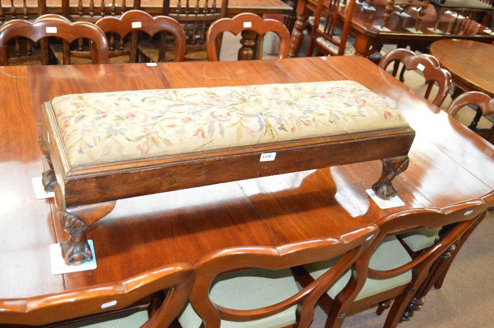 An early 20th century walnut floral woodwork upholstered foot stool on carved scallop shell kneed