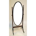 An Edwardian mahogany and chevron strung oval cheval mirror raised on outswept supports,