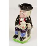 A late 19th century Staffordshire Toby jug modelled as a seated man wearing a tricorn and holding a