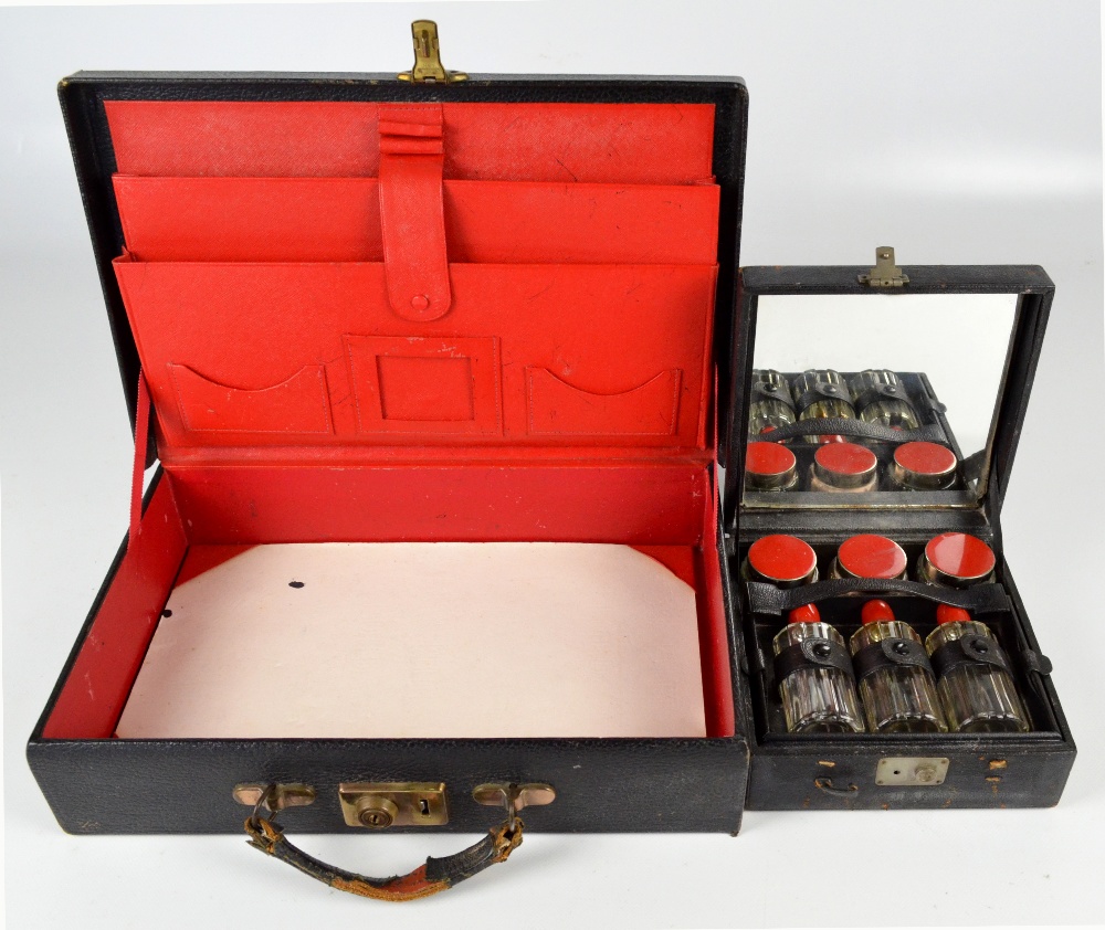 An early 20th century Art Deco style cased cosmetics set comprising three red topped bottles and