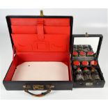 An early 20th century Art Deco style cased cosmetics set comprising three red topped bottles and