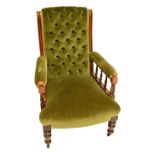 A Victorian walnut framed upholstered gentleman's chair with button back and spindle decorated arm