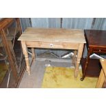 A plank top pine side table with single drawer and turned legs leading to tulip feet.