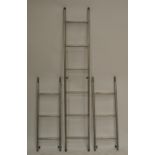 A set of aluminium Gravity-Randall three section surveyors' ladders.