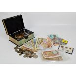 A small rectangular lacquered box containing a quantity of coins;