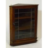 A 19th century oak flat fronted hanging corner cupboard, the glazed hinged doors enclosing shelves,