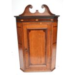 A late George III North Country oak and mahogany crossbanded freestanding corner cupboard.