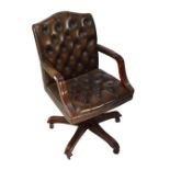 A contemporary leather upholstered revolving office elbow chair.