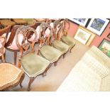 A set of four Victorian walnut dining chairs with padded stuff-over seats and cabriole front legs.