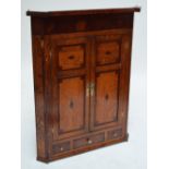 A large George III oak and crossbanded flat fronted corner cupboard with plain cornice above a pair