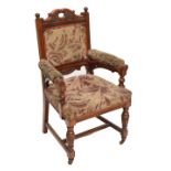 A large Edwardian carved oak framed open arm elbow chair.