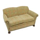 An early 20th century upholstered three piece suite on bun feet,