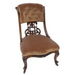 A Victorian walnut serpentine front upholstered lady's chair with foliate scroll carved and button