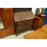 An early 19th century oak bureau with later profuse carving,