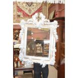 A modern decorative painted wall mirror with scrolling frame.