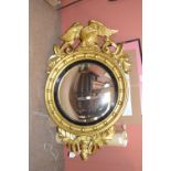 A Regency gilt frame convex wall mirror with Ho Ho bird surmount beside scrolling leaves with a