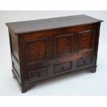 An 18th century oak blanket box with hinged lid above three panelled front and three drawers to the