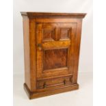 A reproduction small oak cabinet with single door and base drawer, width 46.5cm.