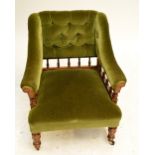 A Victorian walnut framed upholstered gentleman's chair with buttoned and spindle decorated back