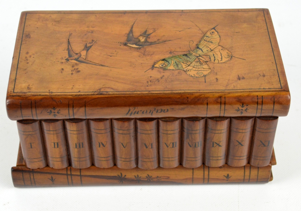An olive wood Sorrento type trinket box in the form of a stack of books decorated to the hinged lid