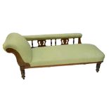 A late Victorian walnut framed upholstered chaise longue with carved foliate motifs,