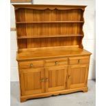 A 20th century pine dresser, boarded plate rack above multiple drawers and cupboard sections,