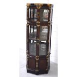 A contemporary Eastern metal-mounted and hardwood glazed display cabinet of octagonal form.