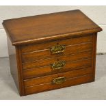 A miniature oak three-drawer chest of drawers with brass handles, width approx 42cm.