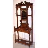 An early 20th century mahogany mirror back hallstand, broken swan neck pediment over central mirror,