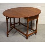 An oak drop-leaf dining table, width when extended, approx 140cm.