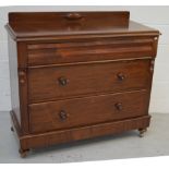 A three-drawer mahogany chest of drawers with top cushion drawer, raised on castors,