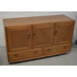 A retro Ercol sideboard with two lower drawers, raised on castors, width 129cm.