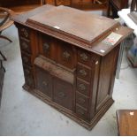 A walnut multi-drawer sewing machine cabinet with inbuilt Singer sewing machine, width 87cm.