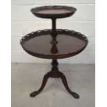 A two-tier mahogany table on knee-carved ball and claw tripod base, width 59cm.